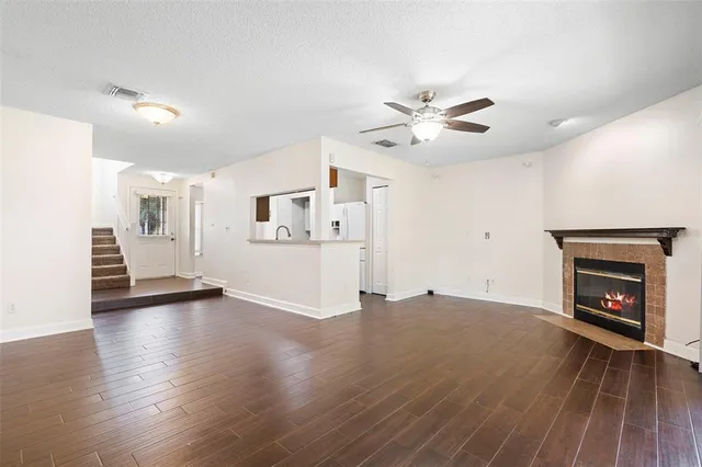 a view of an empty room with a fireplace and a window