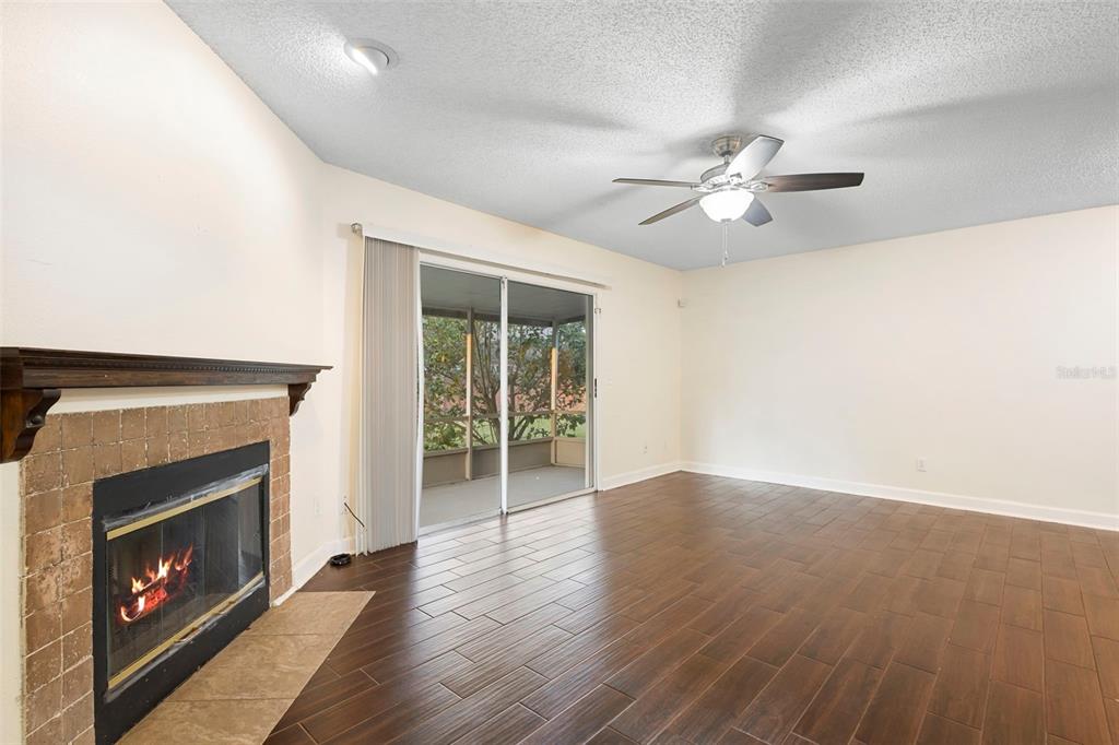 949 Tillery Way, Unit 101 Orlando, FL 32828 - Photo 10 of 38 a view of empty room with wooden floor and fireplace