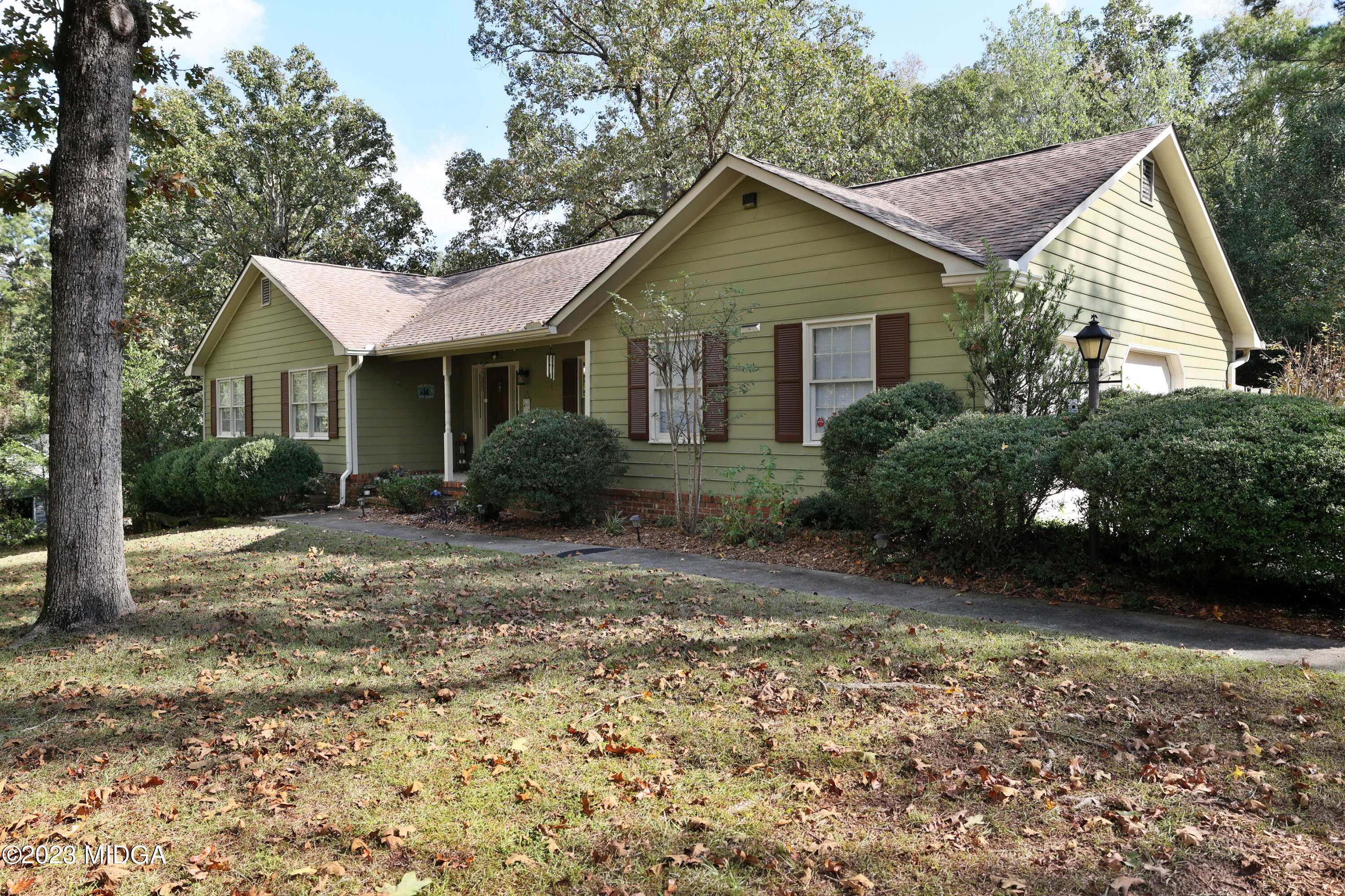 5740 Huddersfield Road Macon, GA 31210 - Photo 1 of 36 a view of a yard in front of a house with plants and large trees