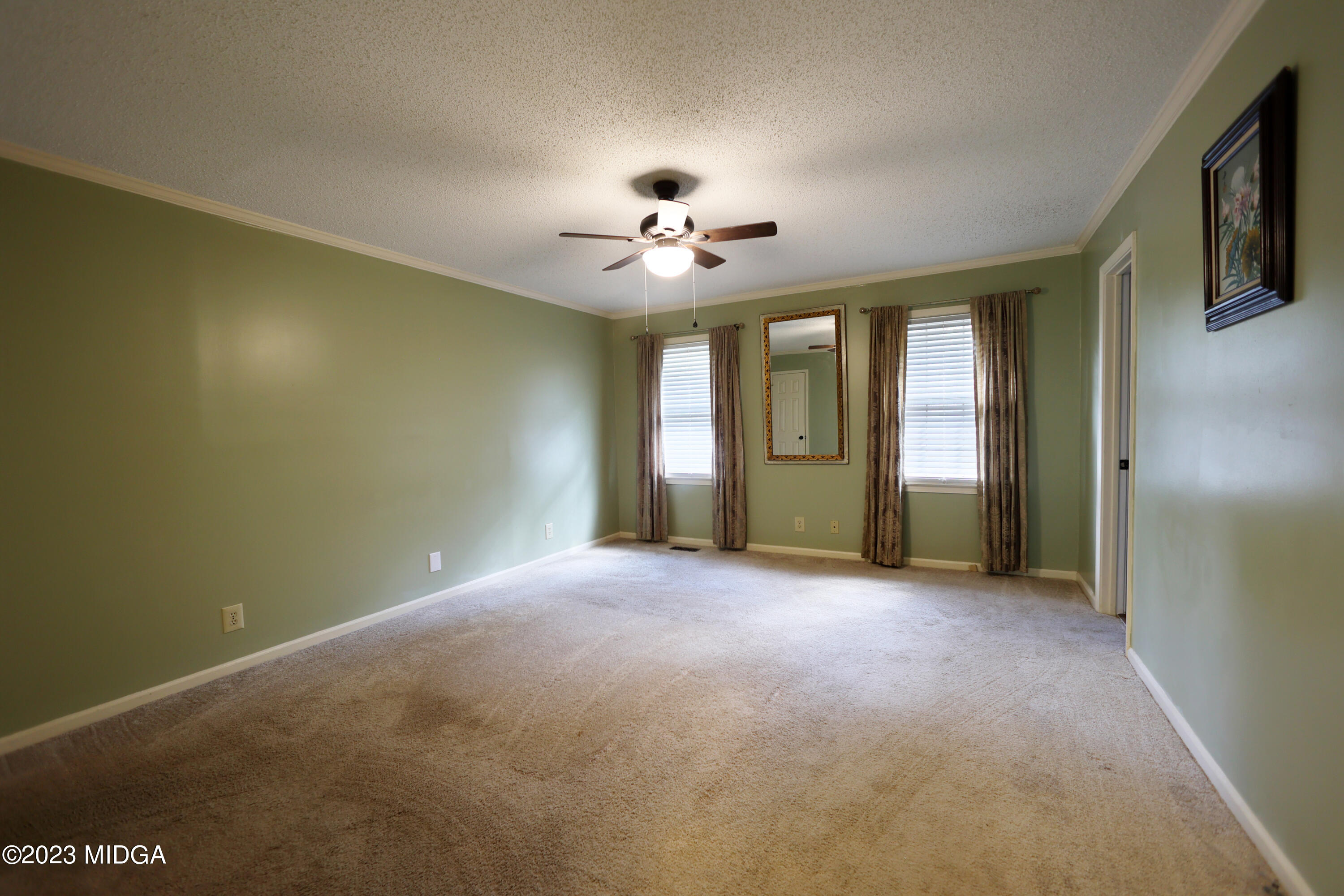 5740 Huddersfield Road Macon, GA 31210 - Photo 20 of 36 an empty room with chandelier fan and windows