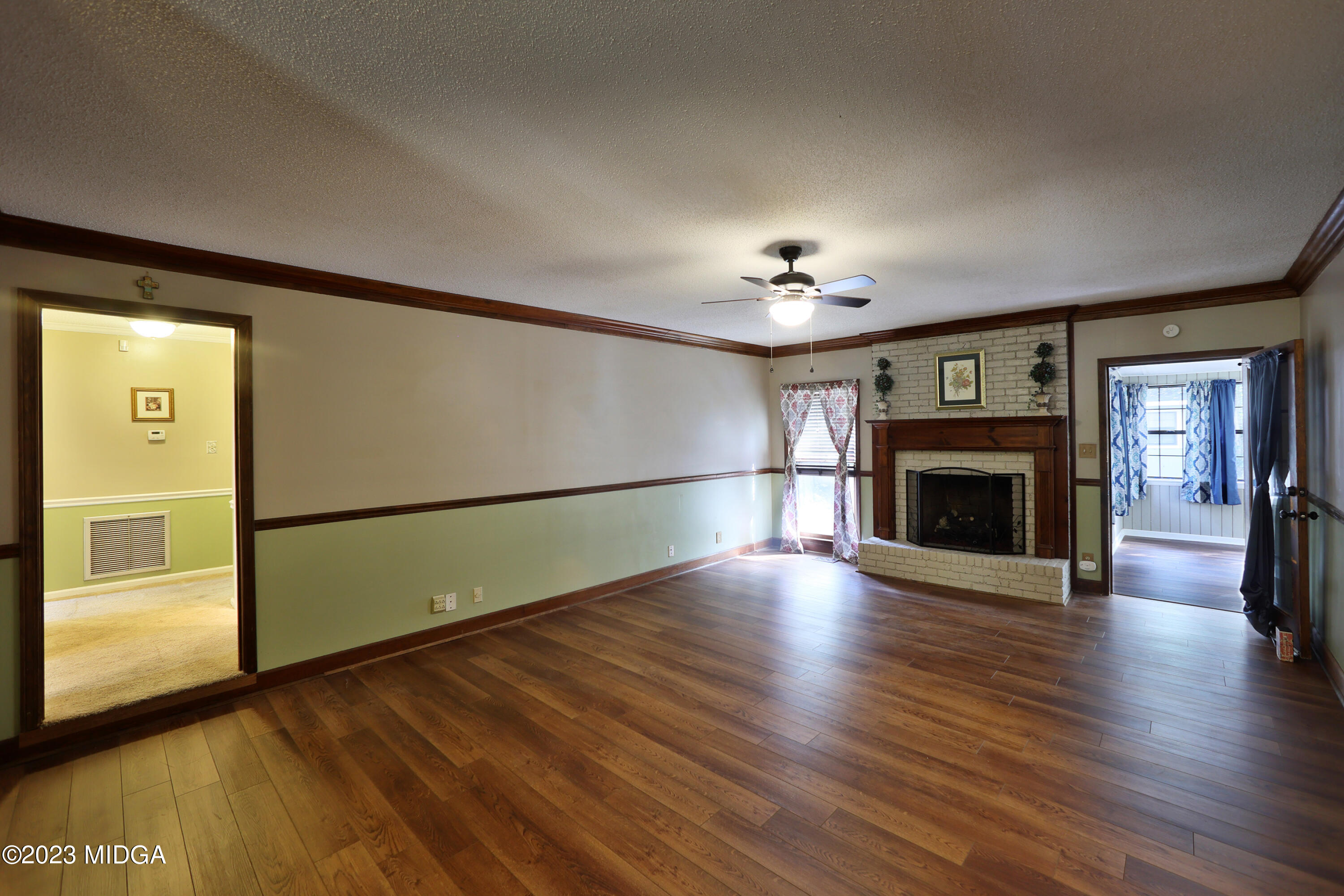 5740 Huddersfield Road Macon, GA 31210 - Photo 6 of 36 a view of an empty room with wooden floor fireplace and a window