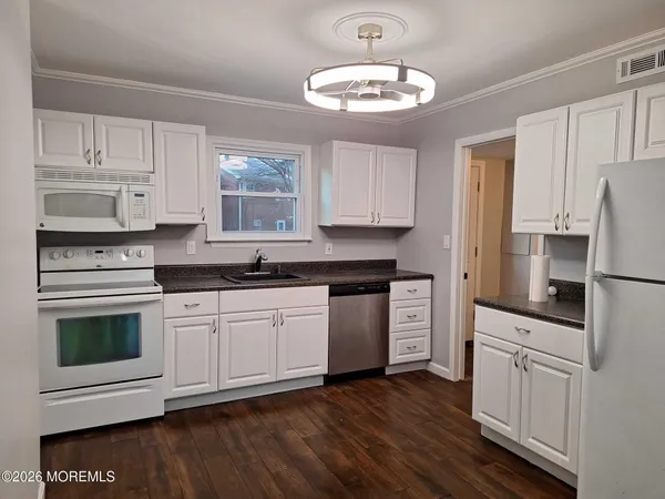 a kitchen with stainless steel appliances white cabinets and a refrigerator