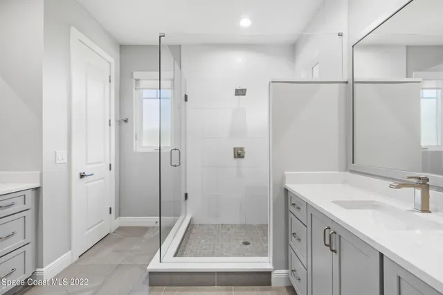a bathroom with a shower sink and mirror