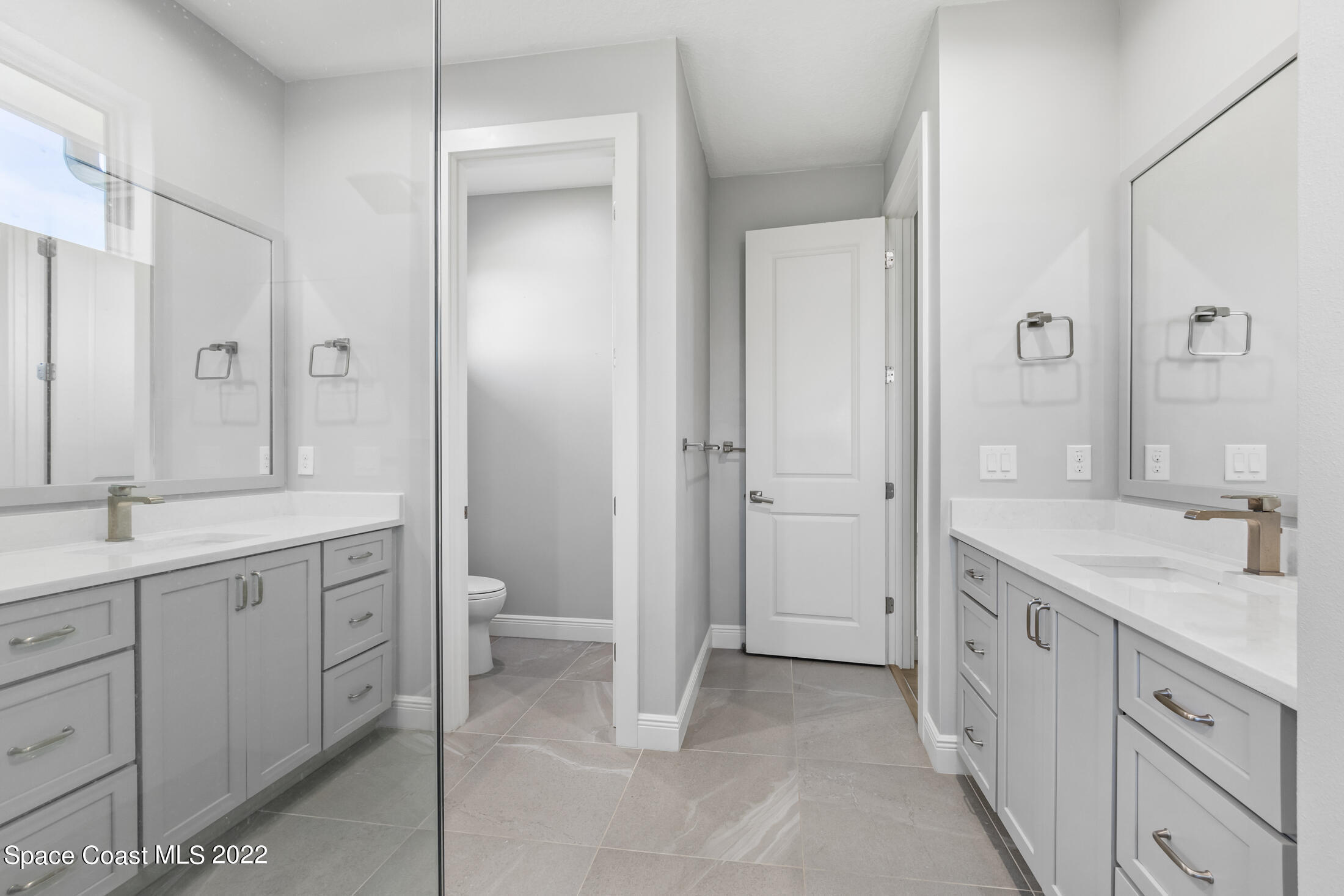 151 24th Street Cocoa Beach, FL 32931 - Photo 13 of 36 a spacious bathroom with a granite countertop sink a toilet and a shower