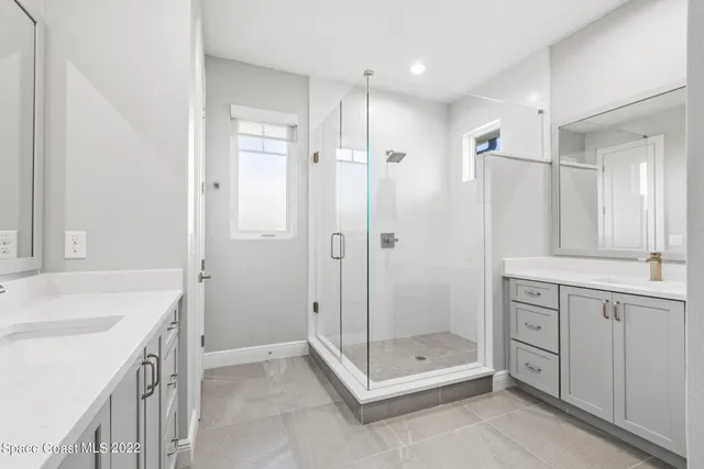 a bathroom with a shower sink vanity and mirror