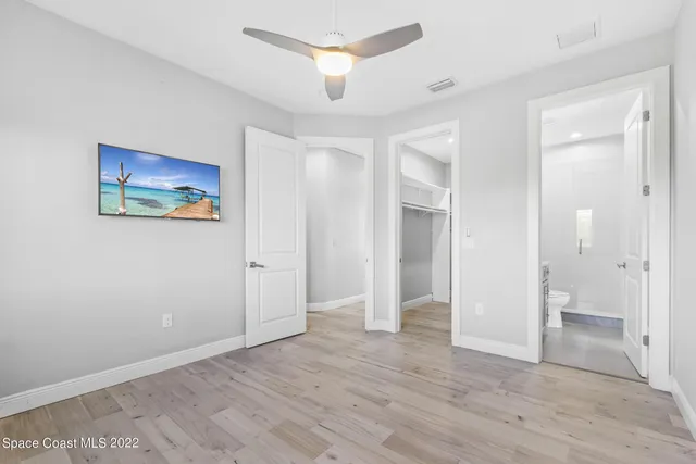 wooden floor in an empty room with a bathroom