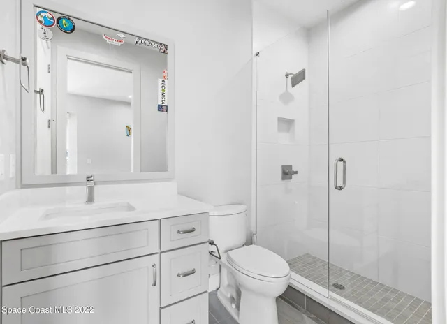 a bathroom with a sink toilet vanity and shower