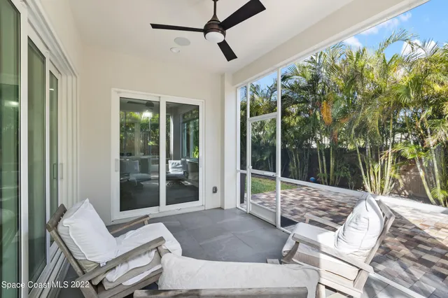 a living room with patio furniture and a floor to ceiling window