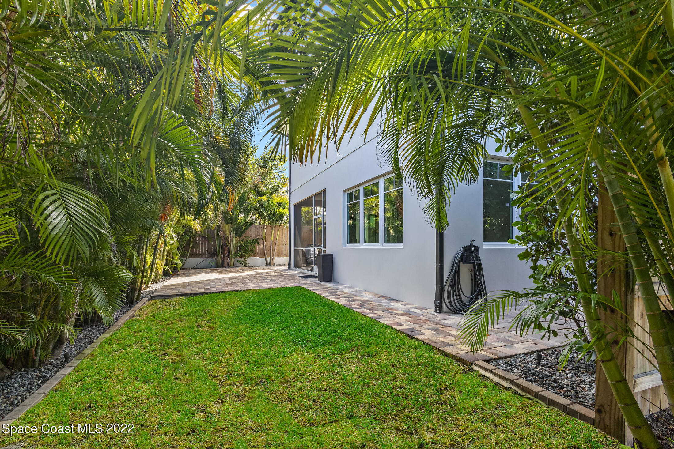 151 24th Street Cocoa Beach, FL 32931 - Photo 34 of 36 a front view of a house with a yard and trees
