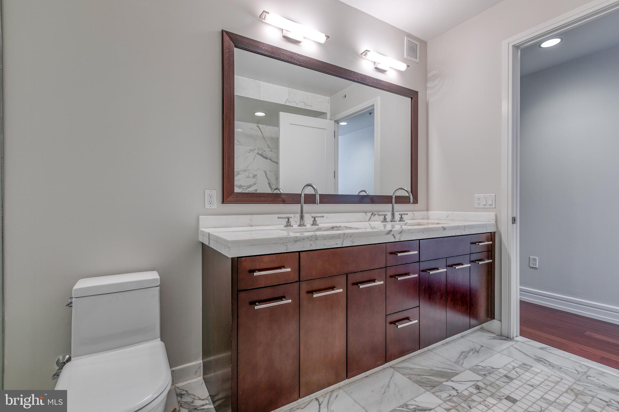 1414 South Penn Square, Unit 16A Philadelphia, PA 19102 - Photo 15 of 34 a bathroom with a toilet a sink and mirror