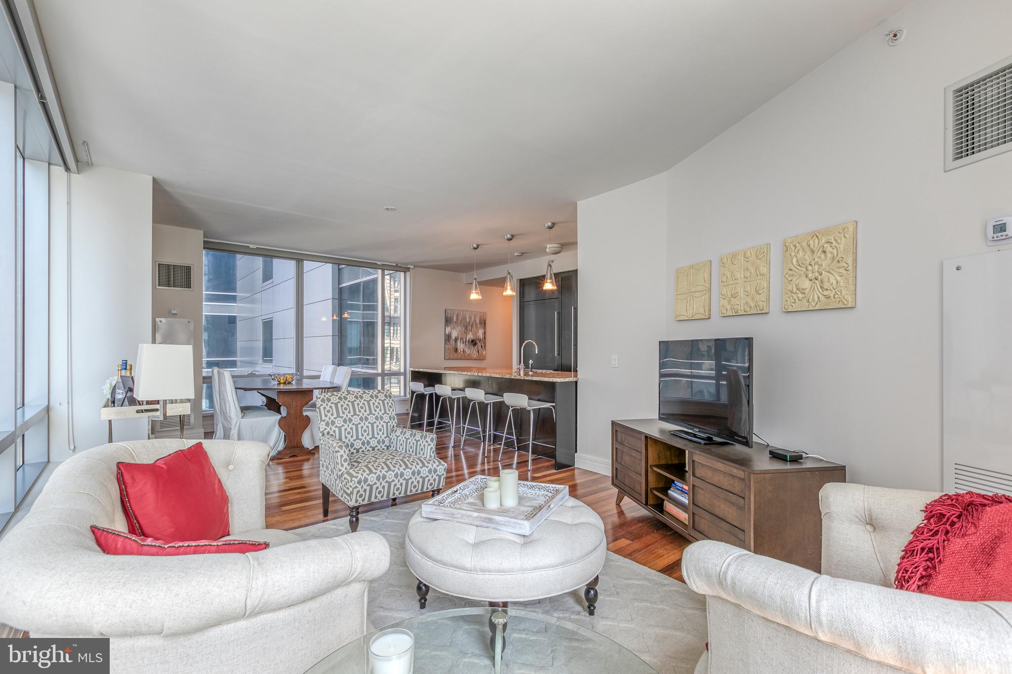1414 South Penn Square, Unit 16A Philadelphia, PA 19102 - Photo 4 of 34 a living room with furniture a flat screen tv and a large window