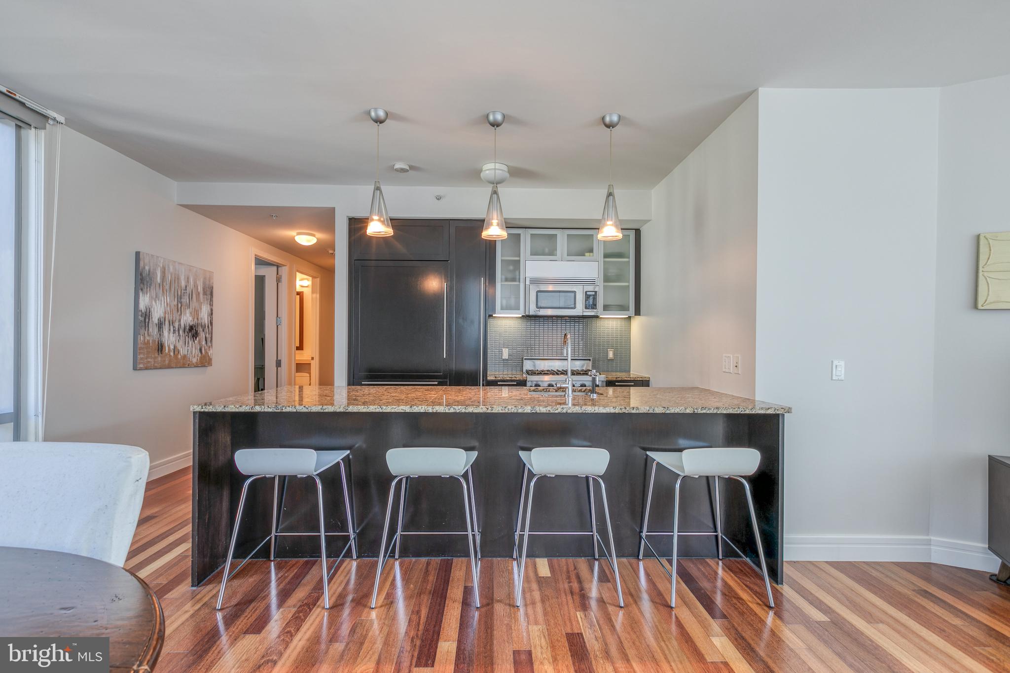 1414 South Penn Square, Unit 16A Philadelphia, PA 19102 - Photo 7 of 34 a kitchen with stainless steel appliances a dining table chairs and wooden floor