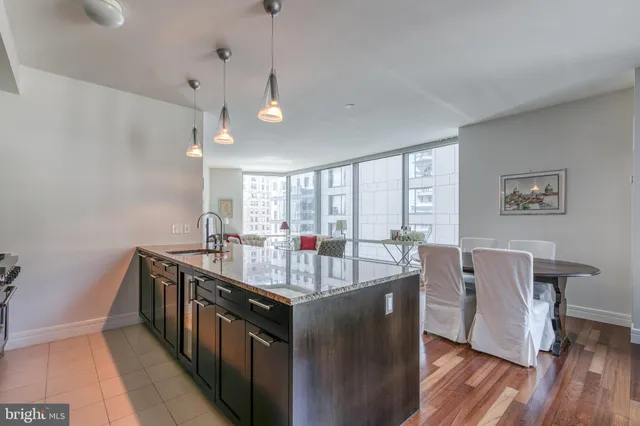 a kitchen with stainless steel appliances granite countertop a sink a stove and wooden floor
