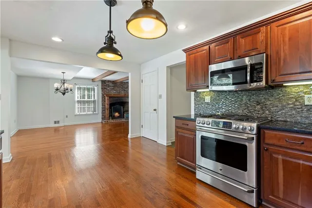 a kitchen with granite countertop wooden floor stainless steel appliances and wooden floor