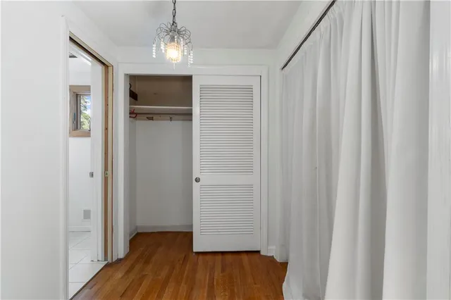 a view of empty room with wooden floor and entryway
