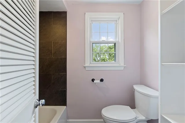 a white toilet sitting next to a bath tub