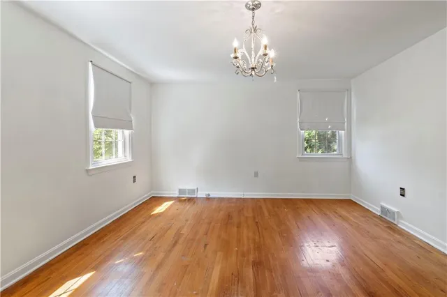 a view of empty room with wooden floor and window