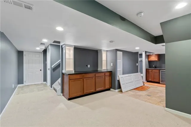 a large kitchen with stainless steel appliances kitchen island granite countertop a refrigerator and a sink