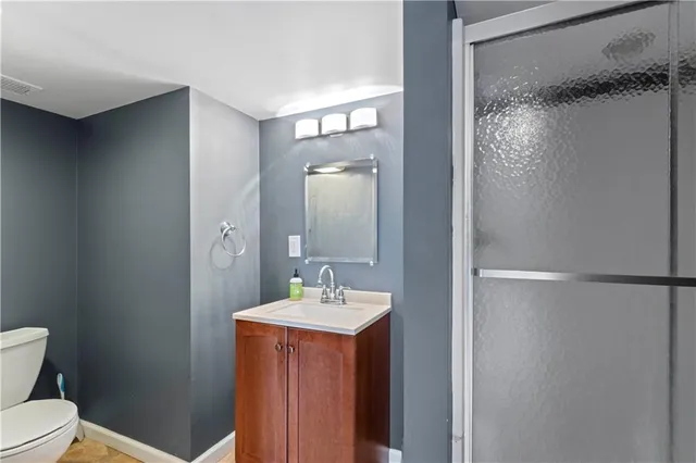 a bathroom with a sink a toilet and shower