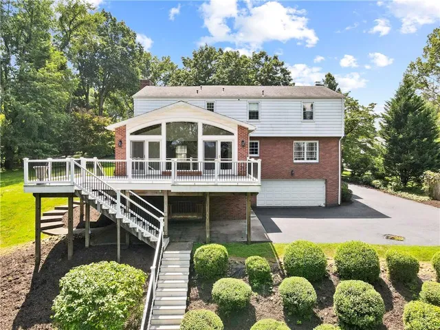 a view of a house with pool and chairs