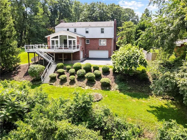 an aerial view of a house with a big yard and large trees