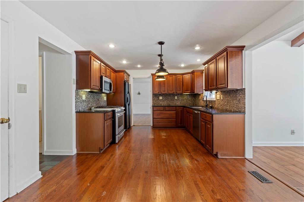24 Oakglen Drive Oakmont, PA 15139 - Photo 8 of 50 a kitchen with stainless steel appliances kitchen island granite countertop wooden floors and a sink
