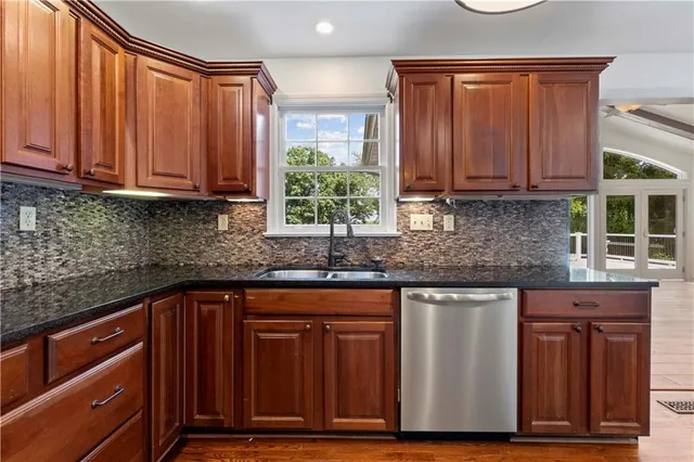 a kitchen with stainless steel appliances granite countertop wooden cabinets a sink and dishwasher