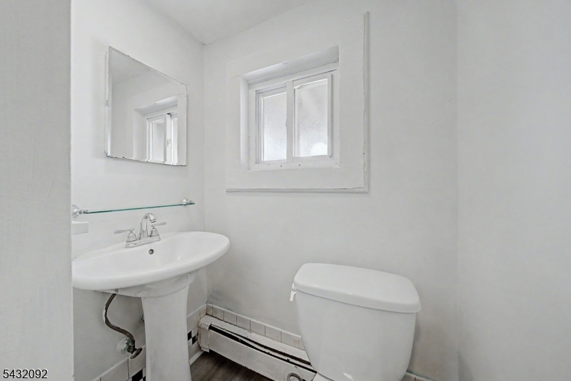 309 Main Street, Unit 3 Boonton, NJ 07005 - Photo 12 of 17 a bathroom with a toilet a sink and a mirror