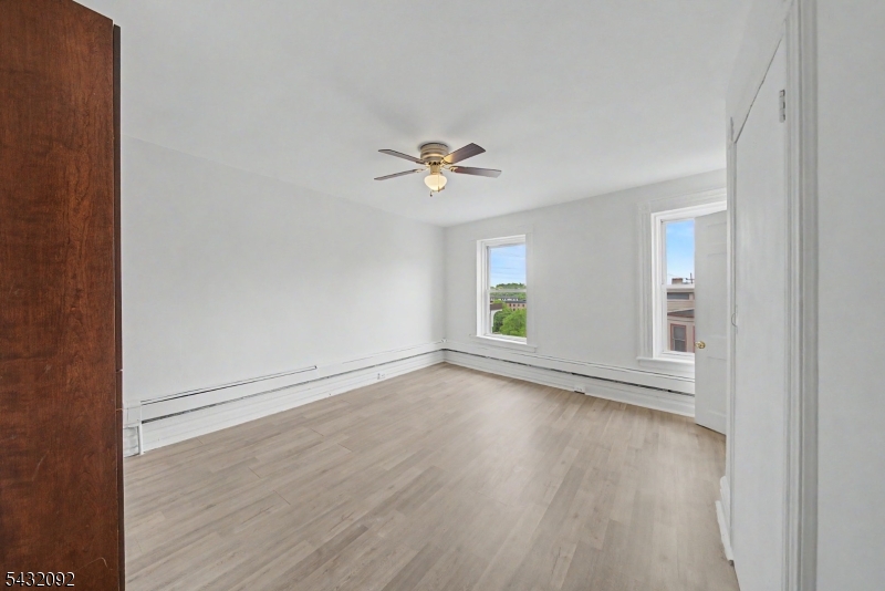 309 Main Street, Unit 3 Boonton, NJ 07005 - Photo 3 of 17 an empty room with wooden floor and windows