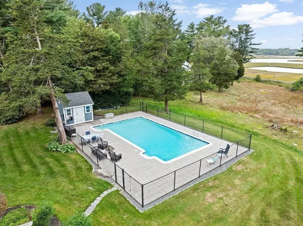 a view of a house with pool and chairs
