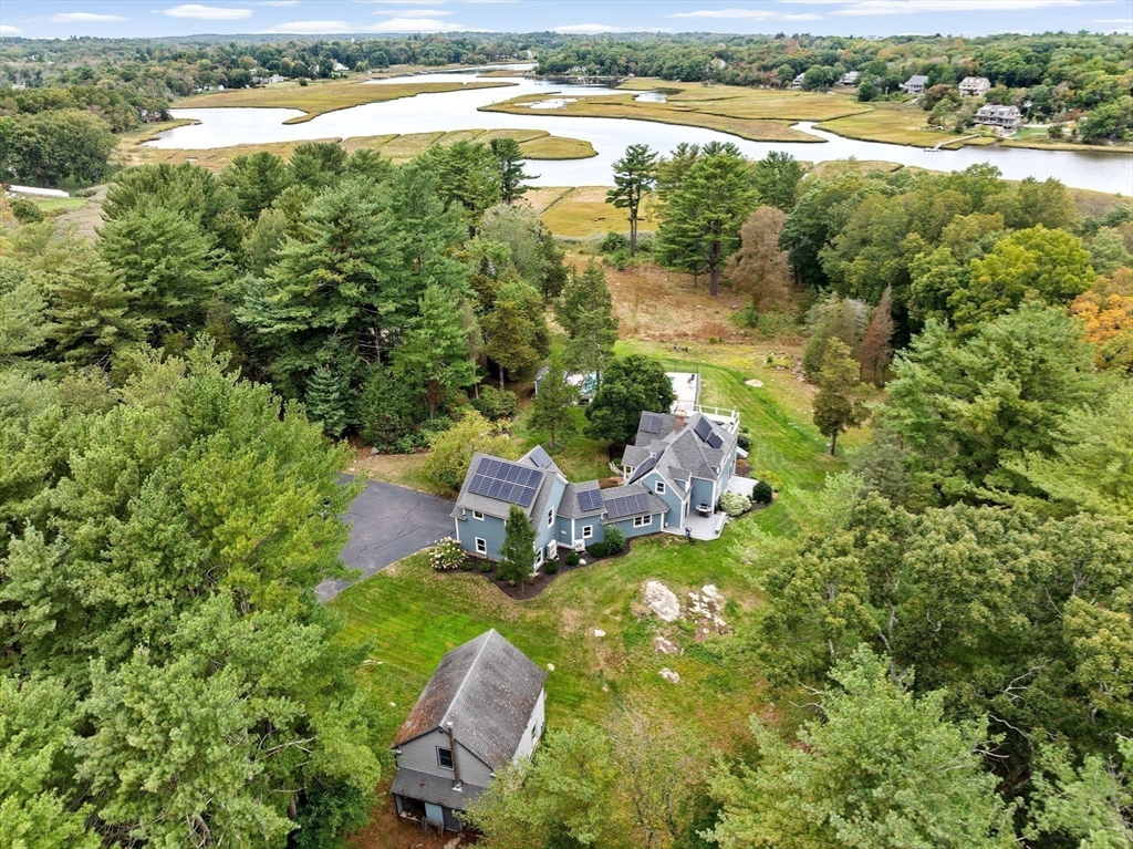 26 Mordecai Lincoln Road Scituate, MA 02066 - Photo 5 of 36 a view of a lake with lawn chairs and large trees