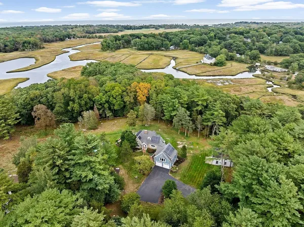 an aerial view of residential houses with outdoor space and trees