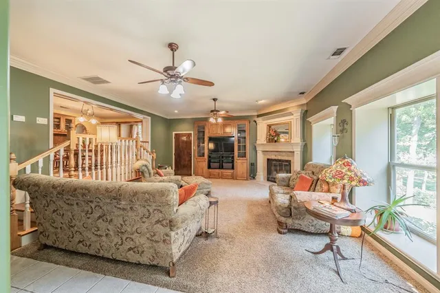 a living room with furniture a fireplace and a chandelier