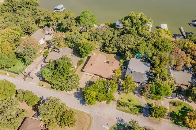 an aerial view of ocean and residential houses with outdoor space