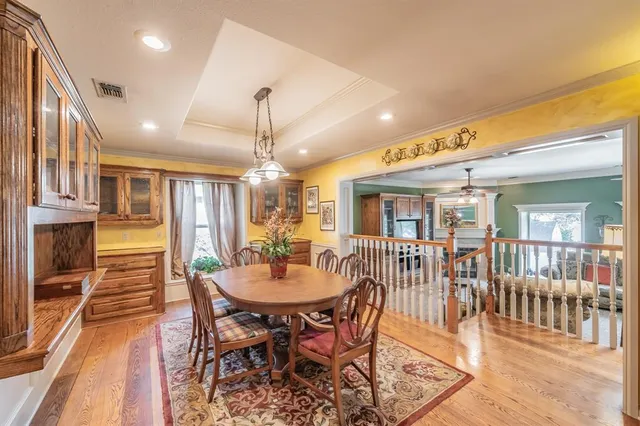 a dining room with furniture a chandelier and wooden floor