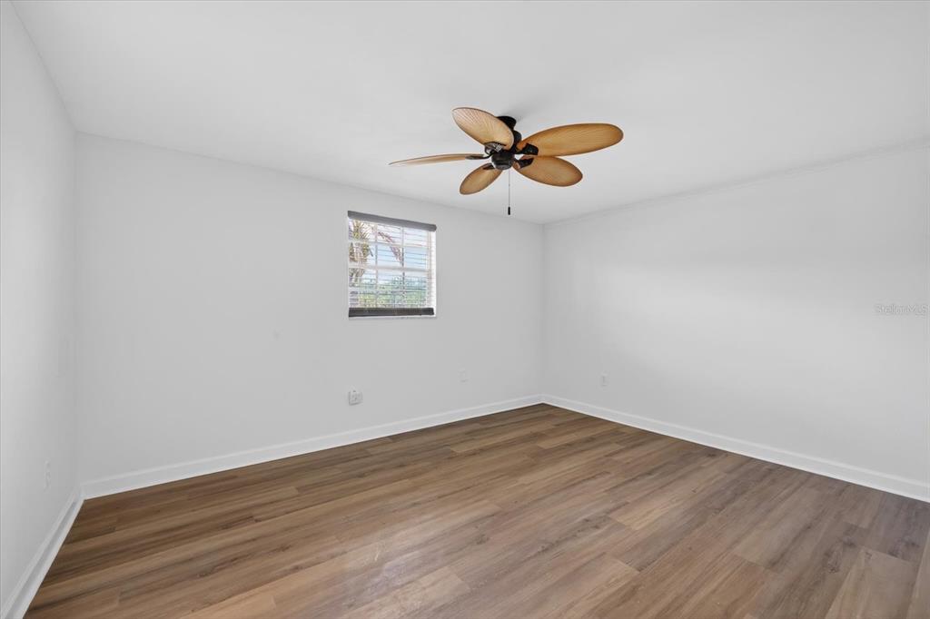 4116 Hampton Drive New Port Richey, FL 34652 - Photo 21 of 35 a view of a room with wooden floor and ceiling fan