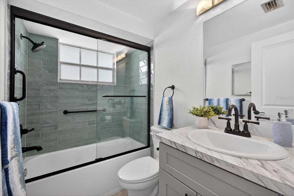 4116 Hampton Drive New Port Richey, FL 34652 - Photo 5 of 35 a bathroom with a granite countertop sink a toilet and shower