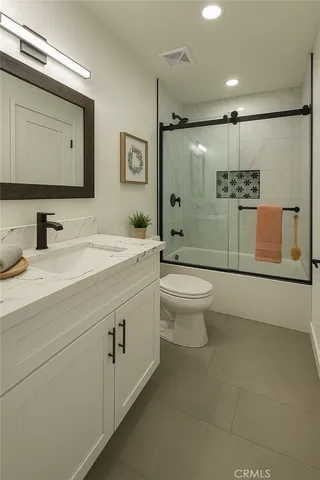 a bathroom with a double vanity sink toilet and mirror