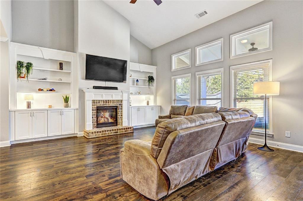4371 Thacker Lane Suwanee, GA 30024 - Photo 11 of 52 a living room with furniture a flat screen tv and a fireplace