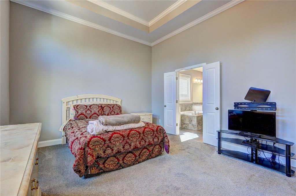 4371 Thacker Lane Suwanee, GA 30024 - Photo 14 of 52 a bedroom with furniture and a flat screen tv