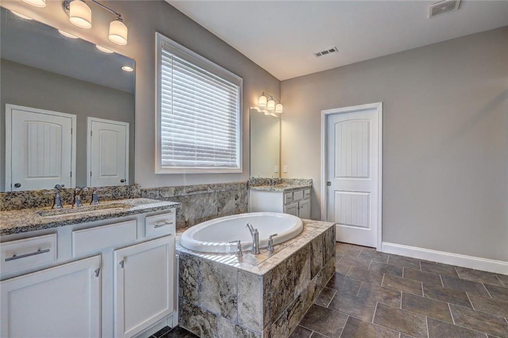 4371 Thacker Lane Suwanee, GA 30024 - Photo 15 of 52 a bathroom with a granite countertop bathtub sink vanity and mirror