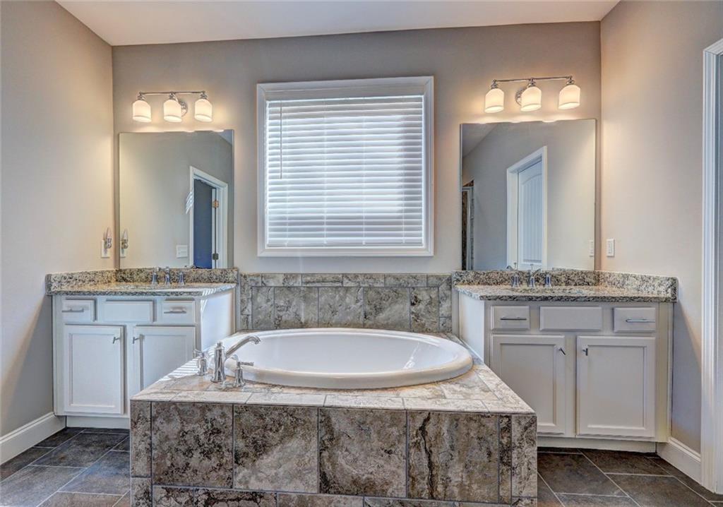 4371 Thacker Lane Suwanee, GA 30024 - Photo 16 of 52 a bathroom with a granite countertop sink and a mirror