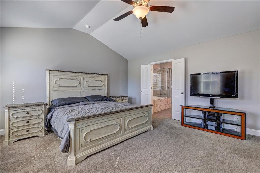 4371 Thacker Lane Suwanee, GA 30024 - Photo 25 of 52 a bedroom with a bed and a flat tv screen on a dresser