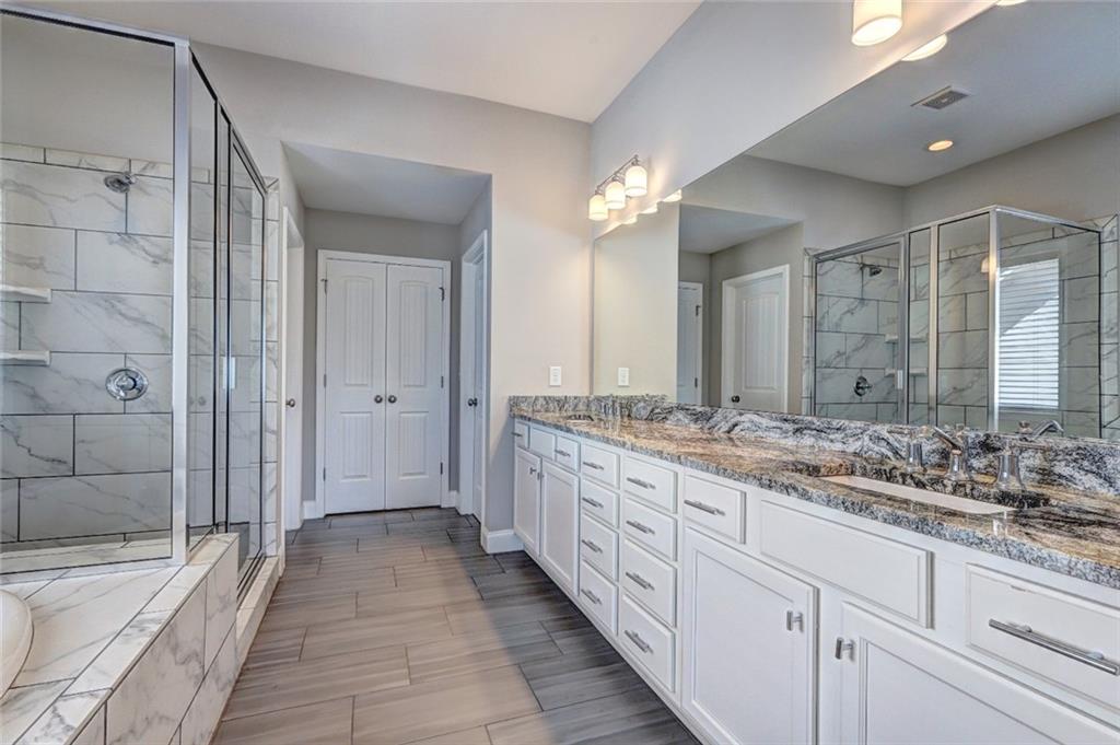 4371 Thacker Lane Suwanee, GA 30024 - Photo 27 of 52 a bathroom with a granite countertop sink mirror and a bathtub