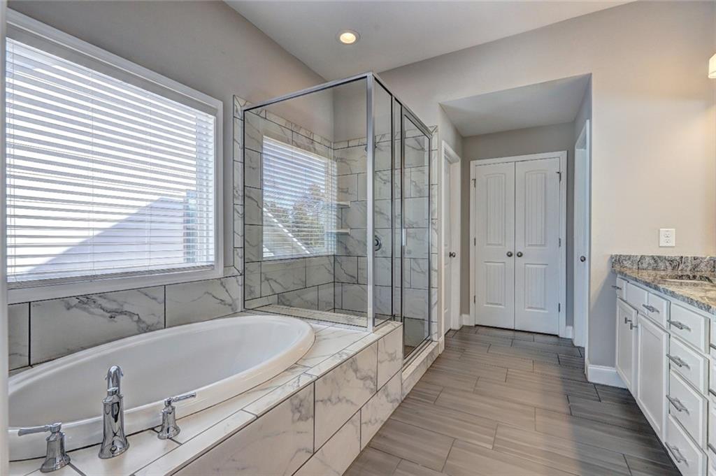 4371 Thacker Lane Suwanee, GA 30024 - Photo 28 of 52 a bathroom with a granite countertop tub sink and mirror