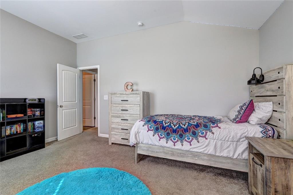 4371 Thacker Lane Suwanee, GA 30024 - Photo 32 of 52 a bedroom with a bed and a book shelf