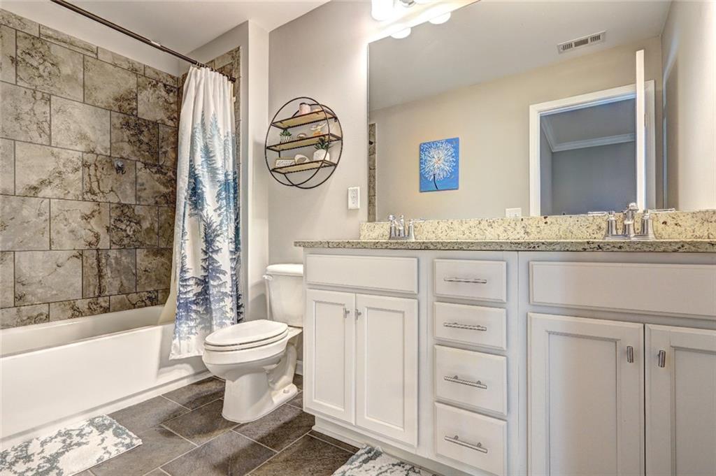 4371 Thacker Lane Suwanee, GA 30024 - Photo 33 of 52 a bathroom with a granite countertop sink toilet mirror vanity and bathtub