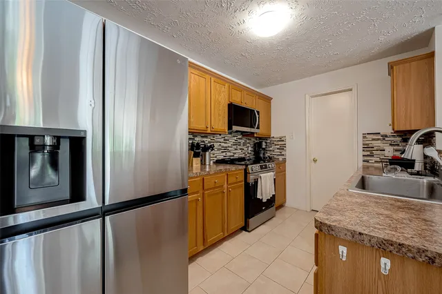 a kitchen with stainless steel appliances granite countertop a sink a stove and a microwave