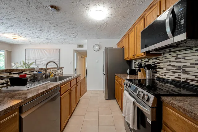 a kitchen with stainless steel appliances granite countertop a stove and a sink
