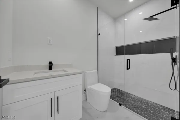 a bathroom with a sink a toilet and a shower